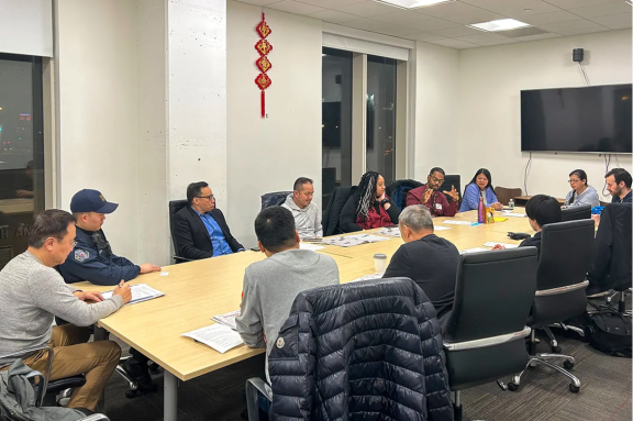 12 people sitting around a conference table 