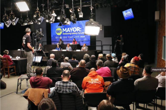 Mayoral candidates sitting on a stage in front of an audience in a TV studio