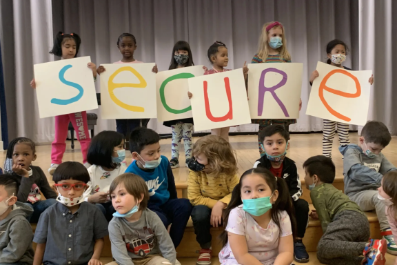 Children from the Kaleidoscope early childhood program in South Philadelphia hold up letters spelling out “Secure”