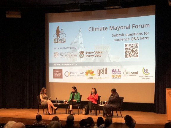 Photo of candidates and journalist on stage during Climate Mayoral Forum