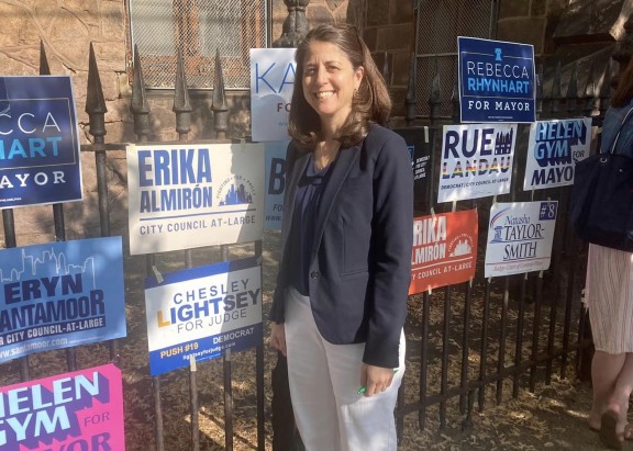 Chesley Lightsey standing in front of a fence with a lot of political signage