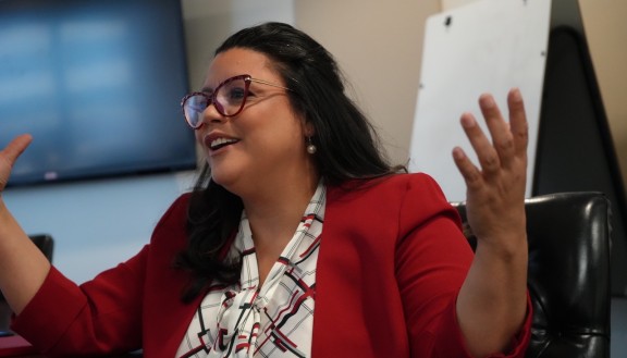 Luz Colón smiling and gesturing with arms open 