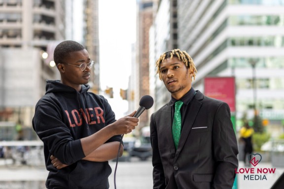 One young man interviewing another young man on the street in Philadelphia
