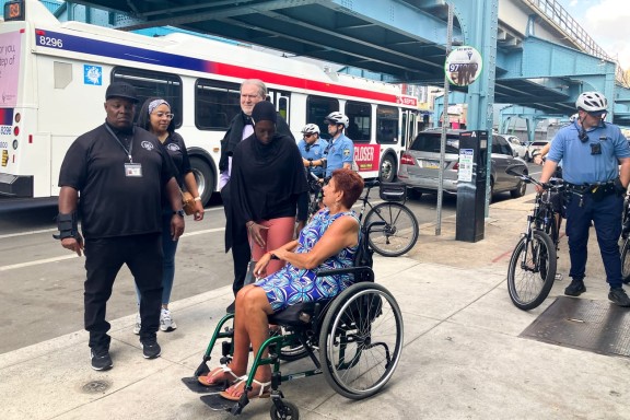 State officials talking to a resident of Kensington on a sidewalk