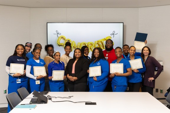 Health care workers holding certificates and celebrating the completion of a skills training