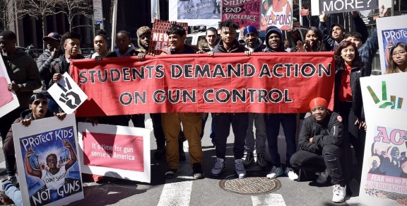 A student group holds a banner demanding gun control