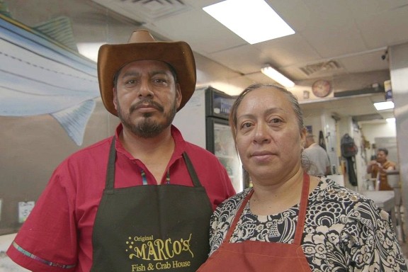Alma and her husband, Marcos Tlacopilco, standing in their fish business