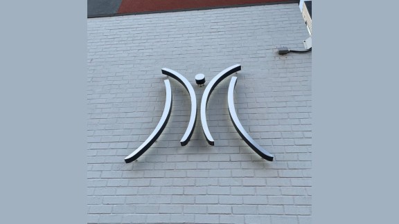 A metal M logo on the Mazzoni Center