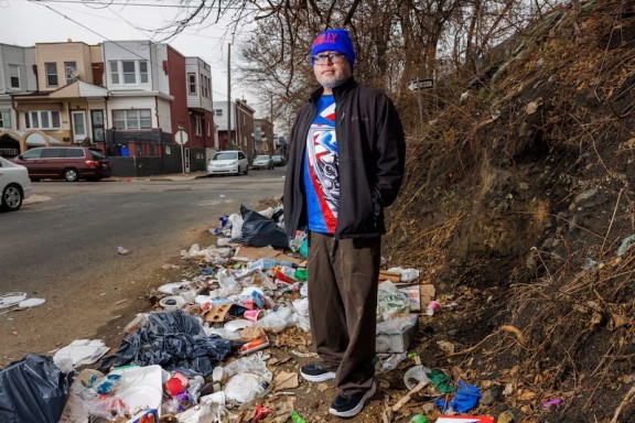 A man standing on a dumping site in the Kensington neighborhood of Philadelphia