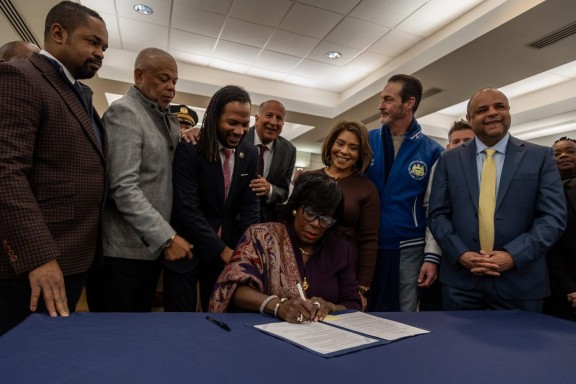 Mayor Cherelle Parker signs an executive order during a press conference unveiling the Kensington Wellness Court at the 24th and 25th Police District on Jan. 21, 2025.