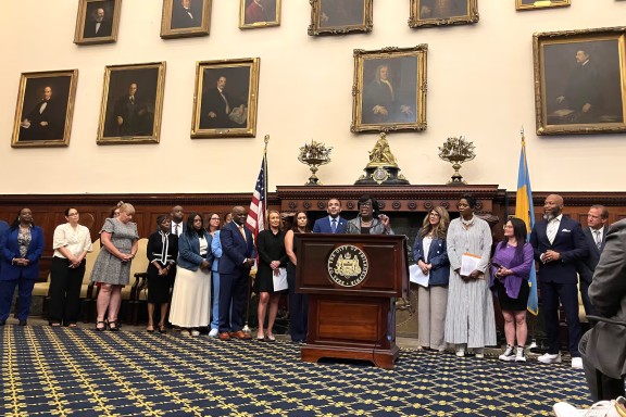 Philadelphia Mayor Cherelle Parker, flanked by Superintendent Tony Watlington and Education Chief Debora Carrera, announces that 15 new schools will participate in the “extended day, extended year” school initiative at Philadelphia City Hall on Friday, June 27, 2025. (Carly Sitrin / Chalkbeat)