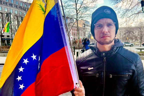Alex Moreno, president of Gente de Venezuela, holding a Venezualan flag