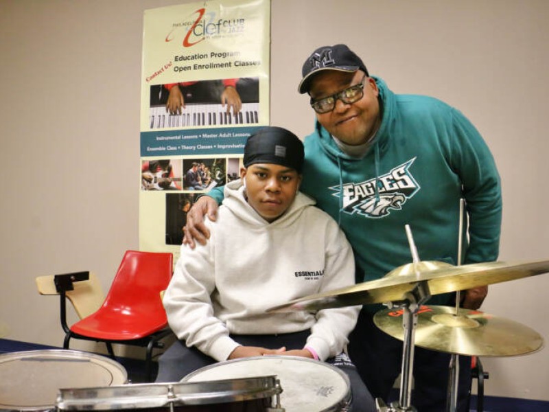 Father and son behind a drum set