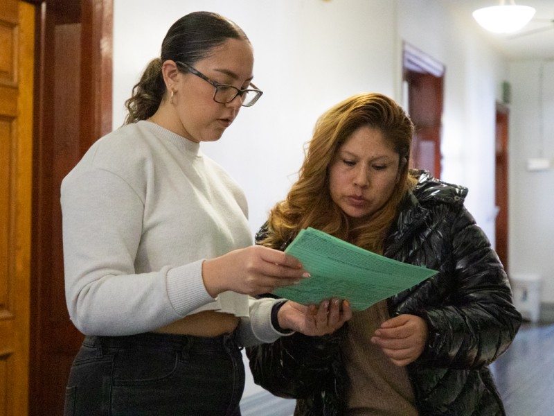 Two Latine people looking over a tax form