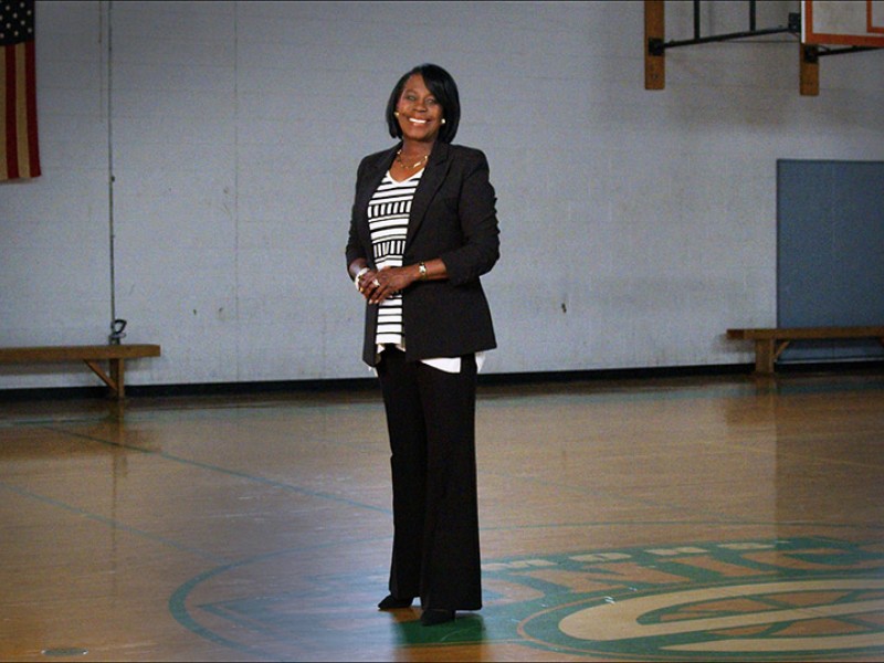 Cherelle Parker smiling at the camera and standing in a school gymnasium 