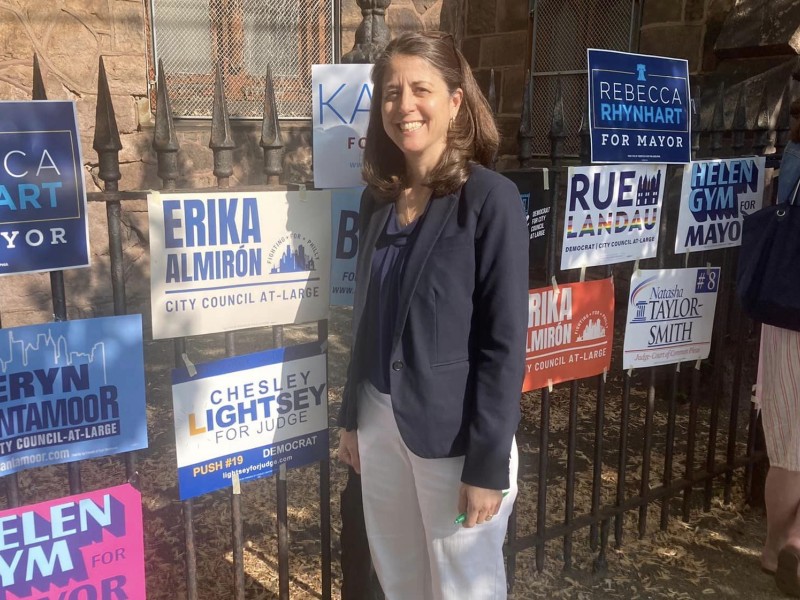 Chesley Lightsey standing in front of a fence with a lot of political signage