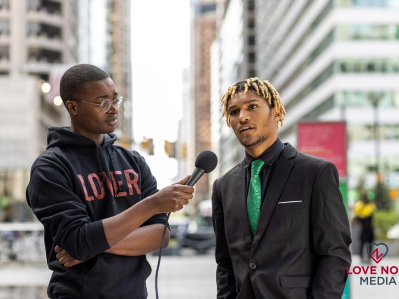 One young man interviewing another young man on the street in Philadelphia