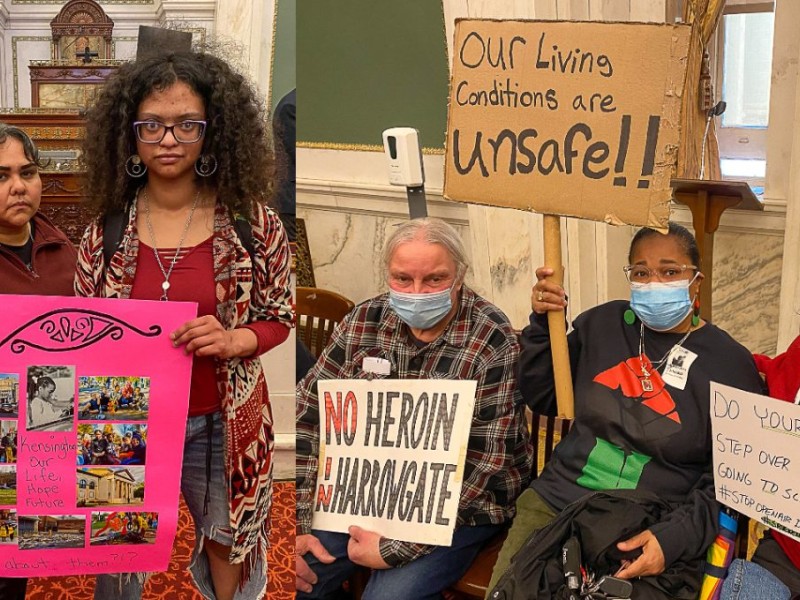 Housing activists holding up signs at city council meeting