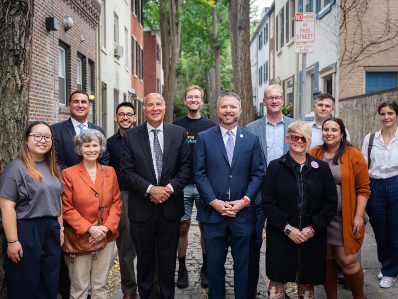 12 smiling local Philadelphia leaders on a historic street