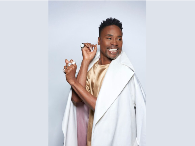 Photo of Billy Porter smiling in a white coat