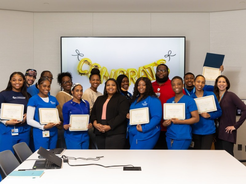 Health care workers holding certificates and celebrating the completion of a skills training