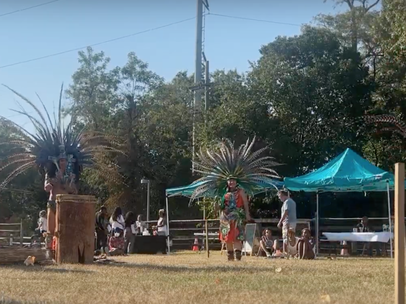 Indigenous people dancing in traditional feathered headdresses at Indigenous Peoples Day in Philly