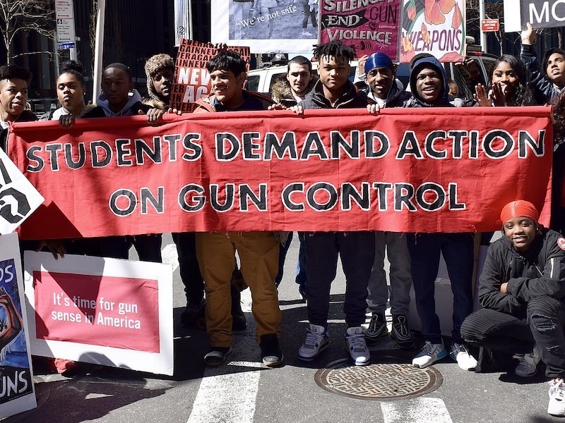 A student group holds a banner demanding gun control