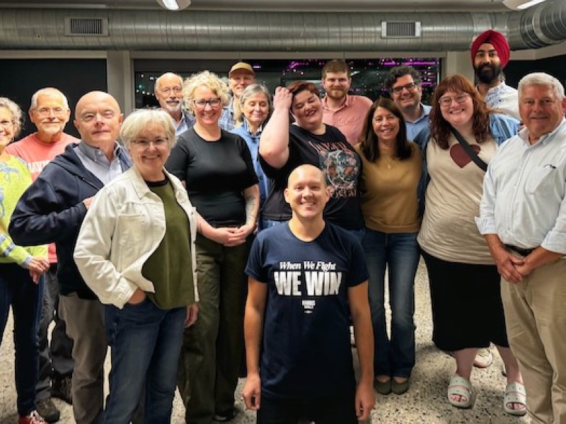Arash Singh (far right, back) stands among other Changing the Conversation Together volunteers.