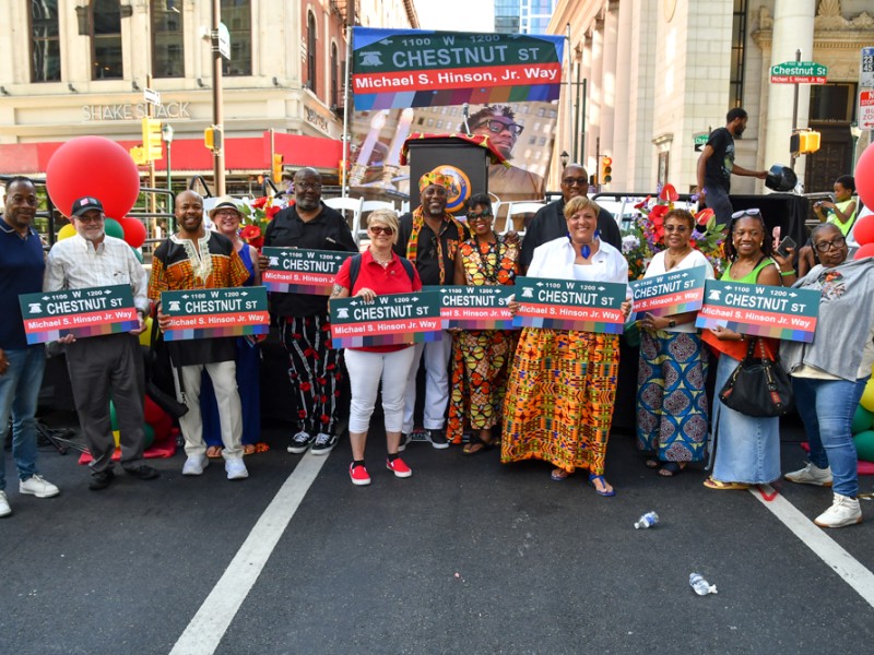 Organizers and speakers pose with signs designating the 1200 block of Chestnut Street as Michael S. Hinson Jr. Way. From left, Dr. Andre Ford, David Fair, Chris Hunter (Dashiki), Roberta Cancellier, Christopher Weaver, Tami Sortman, Lee Carson, Lanette Swopes, Kareem E. Thomas, Tara L. Webb, Rashidah Perry-Jones, Quibila Divine and Sylvia Simms. (Photo: Kelly Burkhardt)