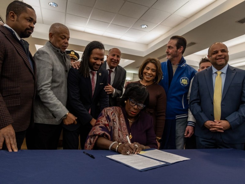 Mayor Cherelle Parker signs an executive order during a press conference unveiling the Kensington Wellness Court at the 24th and 25th Police District on Jan. 21, 2025.