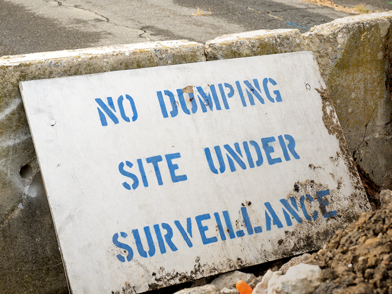 Warning signs at illegal dumping hotspots, such as at this dead end of Lyons Place in Eastwick, can only do so much to reduce the problem. Photo by Troy Bynum.