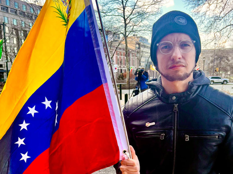 Alex Moreno, president of Gente de Venezuela, holding a Venezualan flag