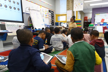 A teacher reads to a group of students at Andrew Hamilton school. A new report found that teachers in their first three years of teaching and teachers of color leave their jobs at higher rates than others. (Carly Sitrin/Chalkbeat)