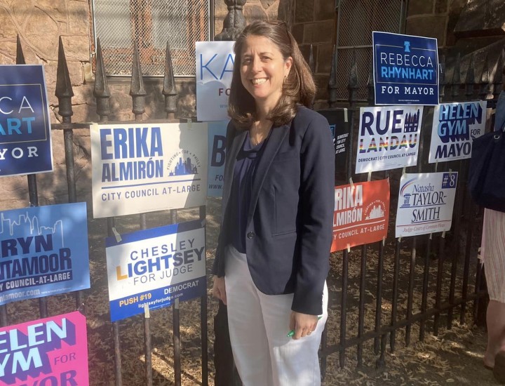 Chesley Lightsey standing in front of a fence with a lot of political signage