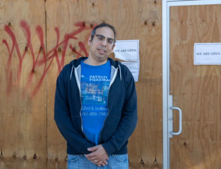 Ben Nachum, owner of Patriot Pharmacy, in front of boarded up storefront