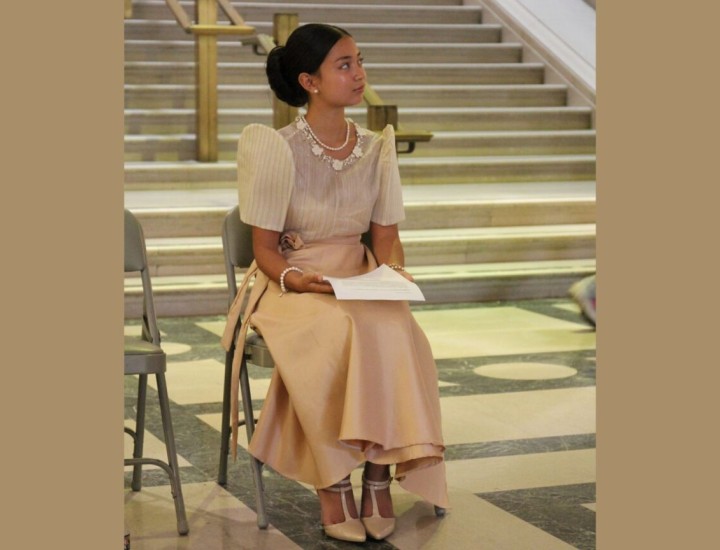 Malaya Ulan seated in a rose gold dress