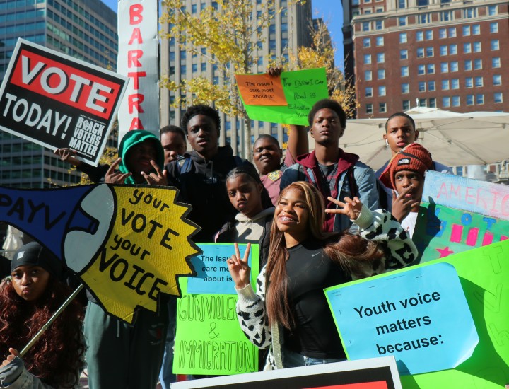 Image of students outside holding youth vote signs